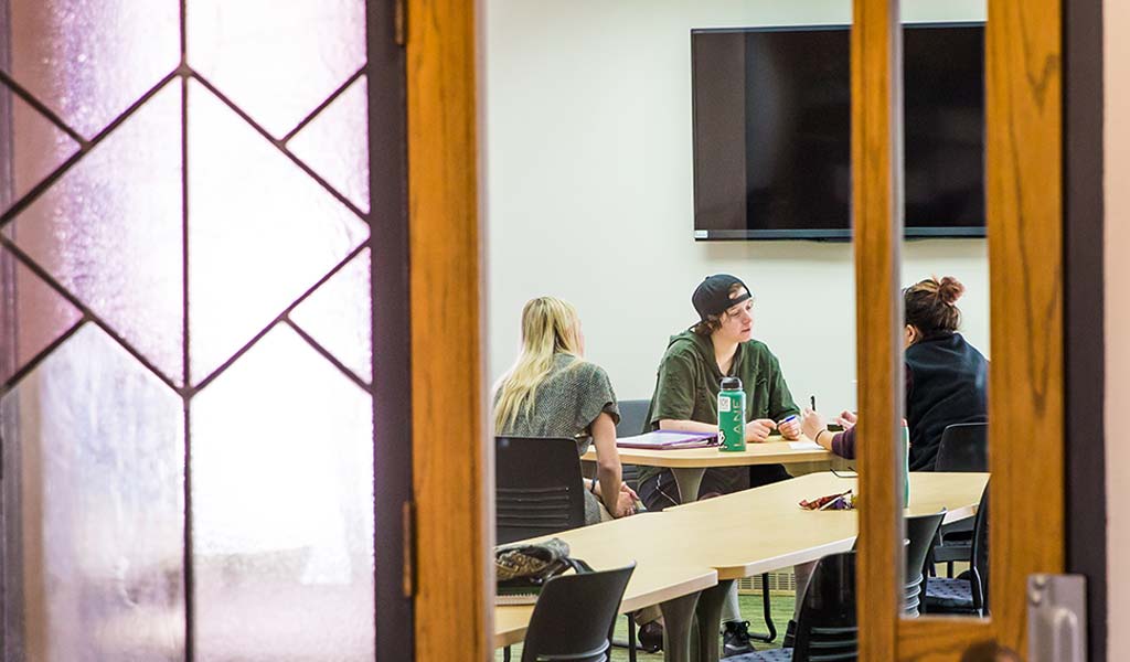 JWU students working on a group project in a classroom.