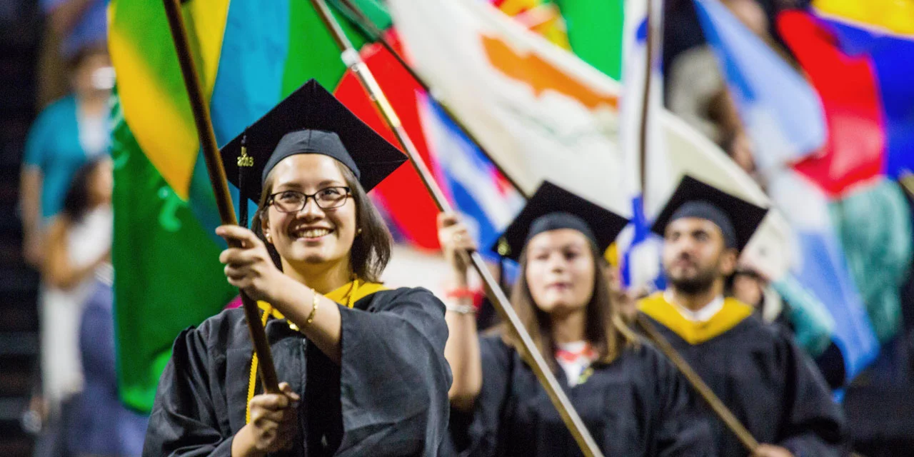 Procession of flags: students carry flags from countries that our graduates represent.