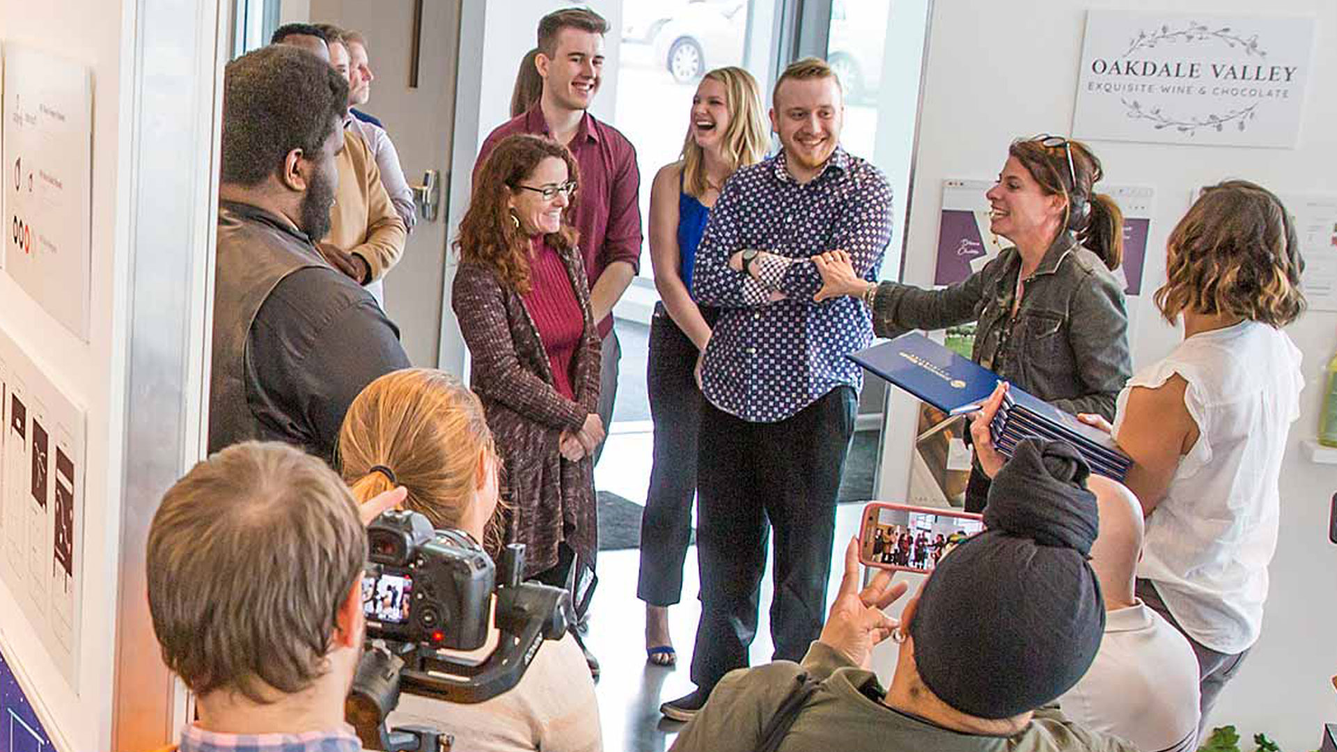 Associate Professor Deana Marzocchi with students at the annual REVEAL show of senior portfolios and exhibits