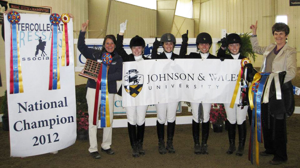 Tierney Boyd and JWU students and faculty posing with 2012 IDA National Championship banner