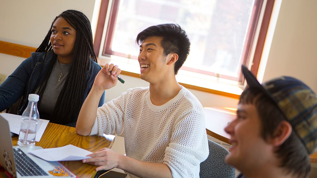 Photo of student working with group in class