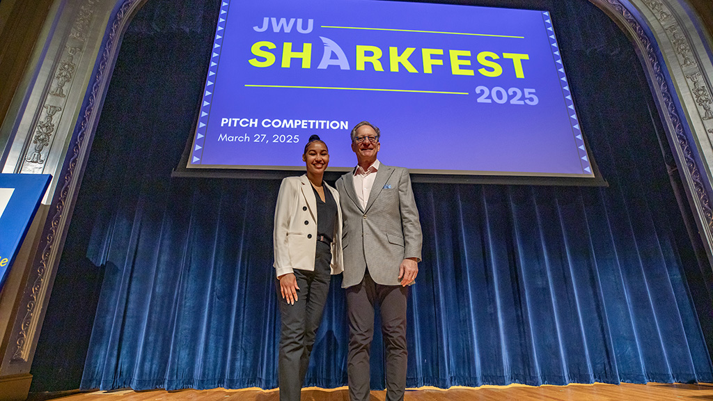 A student and professor standing on a stage
