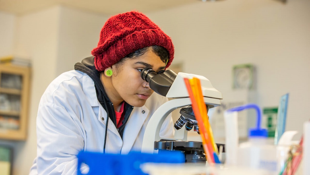 jwu student using microscope in biology lab