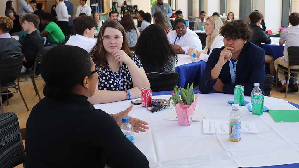 Three students sitting at a table talking