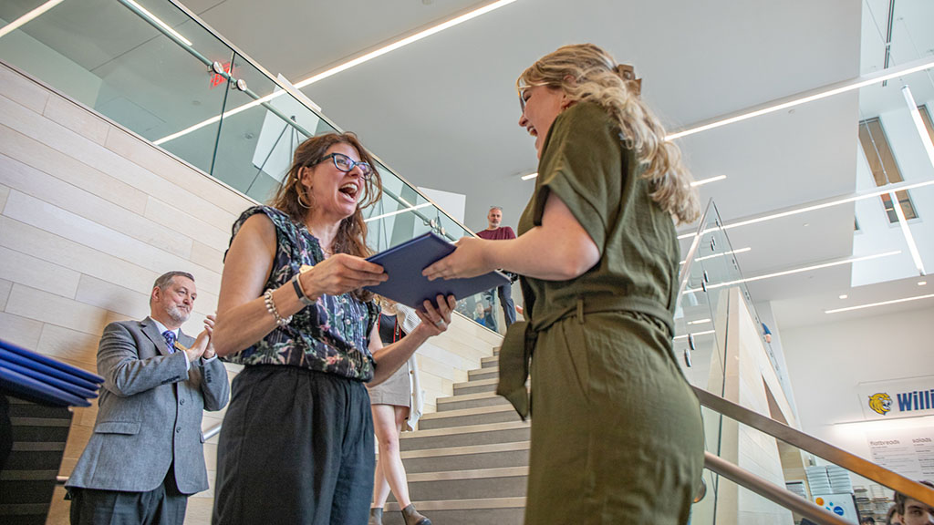 Professor Deanna Marzocchi handing a student their design certficate