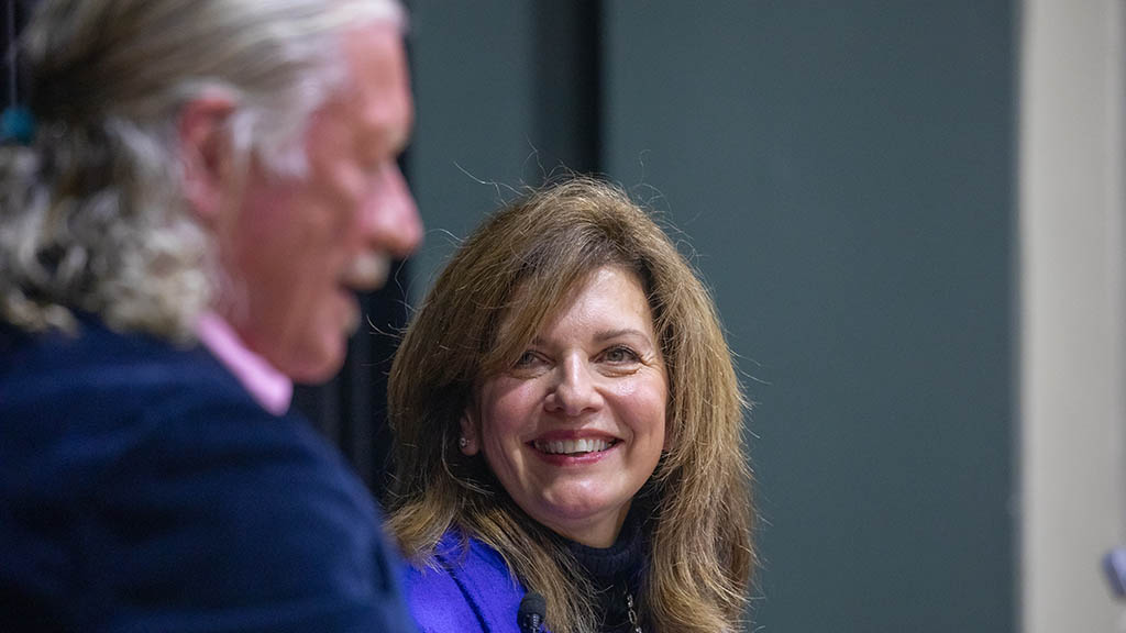 a photo of Marie Bernardo-Sousa smiling while on stage for a VIP lecture