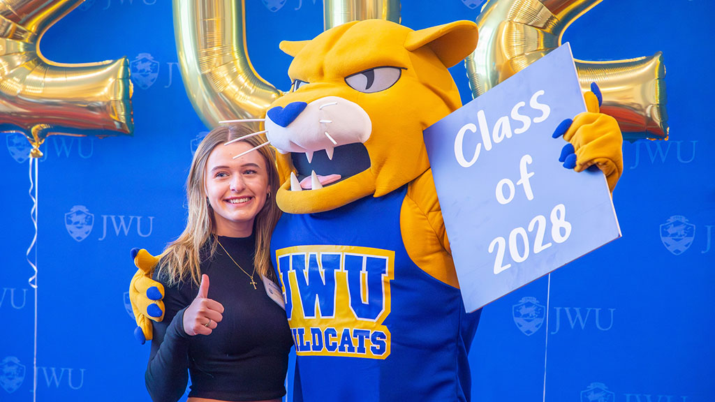 Wildcat Willie posing with a girl giving a thumbs up to the camera