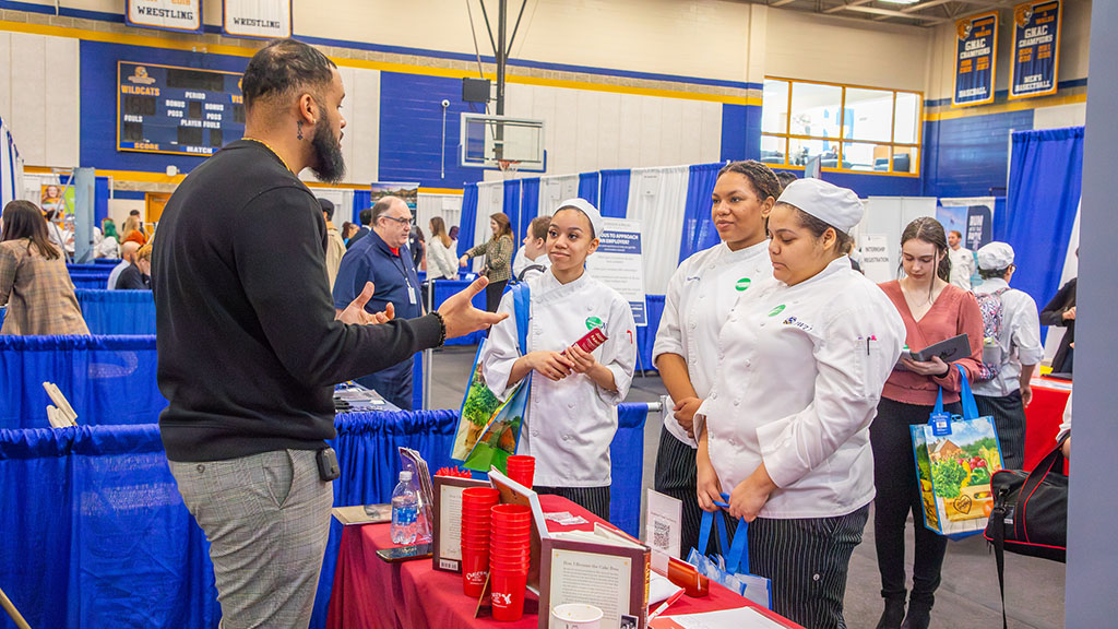 A man talking to several JWU culinary students