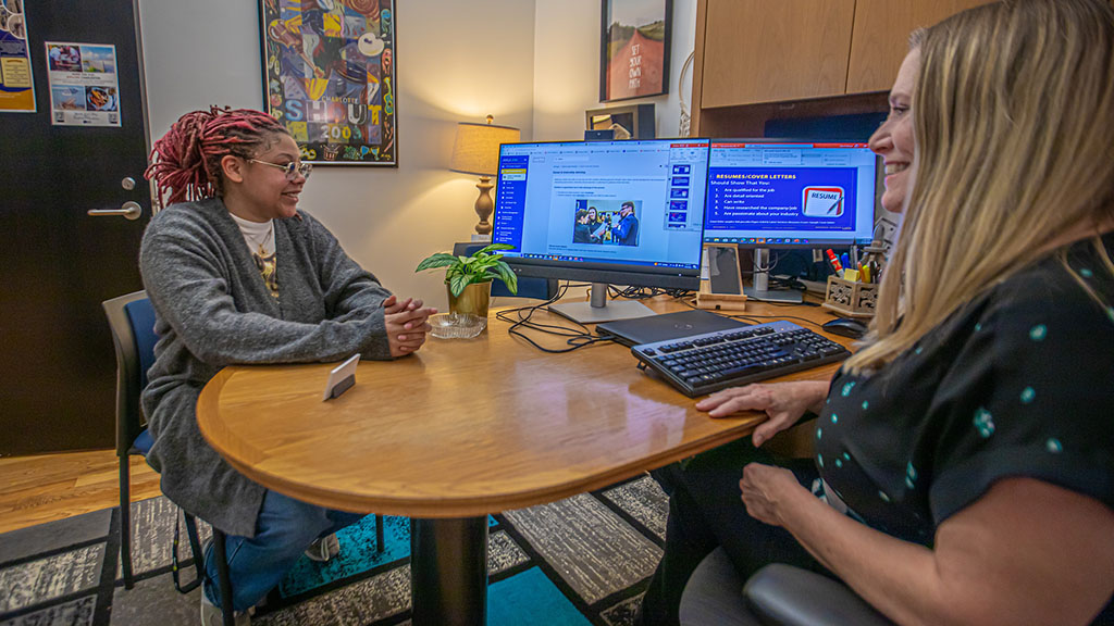 Two women sitting across from each other at a desk