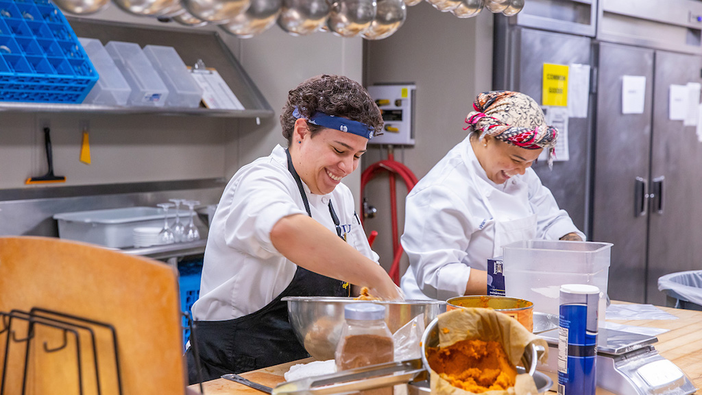 Rence and another student cooking in a kitchen