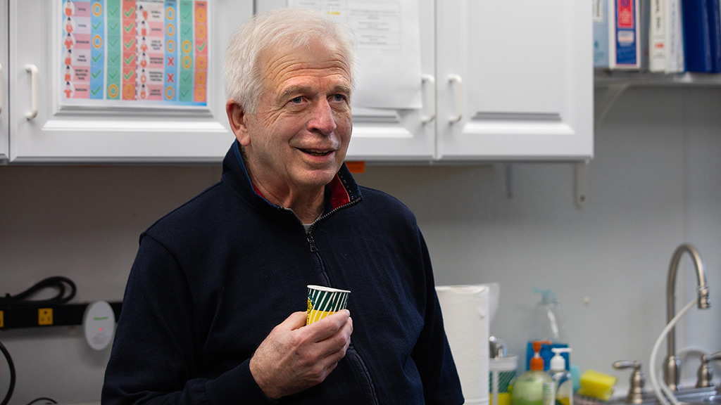 Demetrios “Doc” Kazantzis speaks while holding a cup of Del’s lemonade