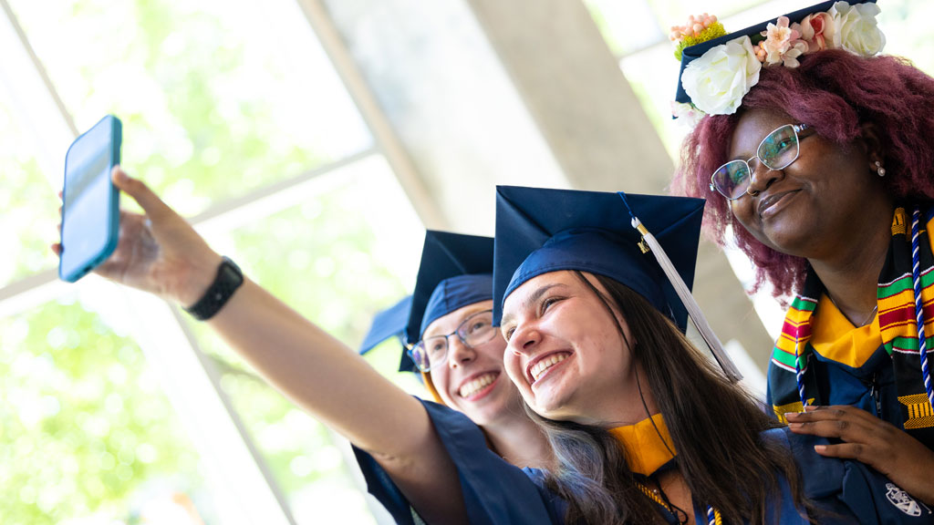 Taking a group grad selfie at Charlotte Commencement.