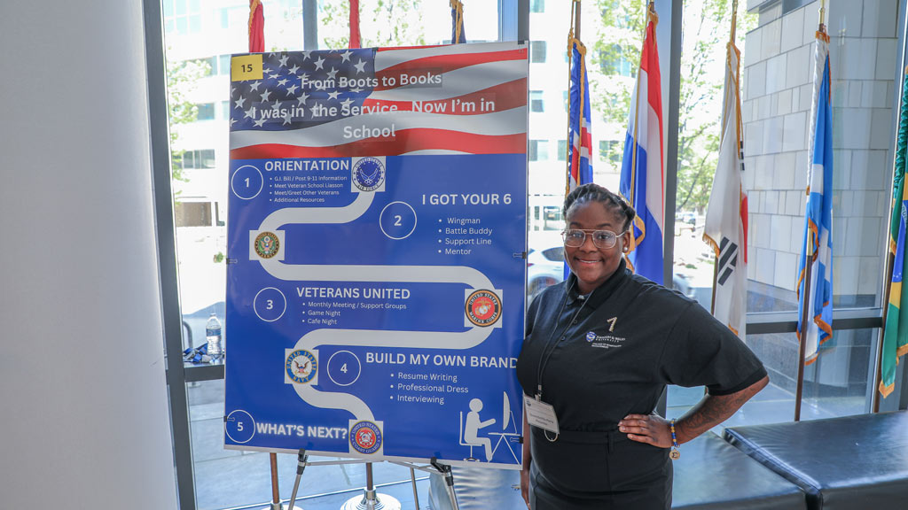 photo of QueenDeifilla Perry ’25 standing in front of her symposium project