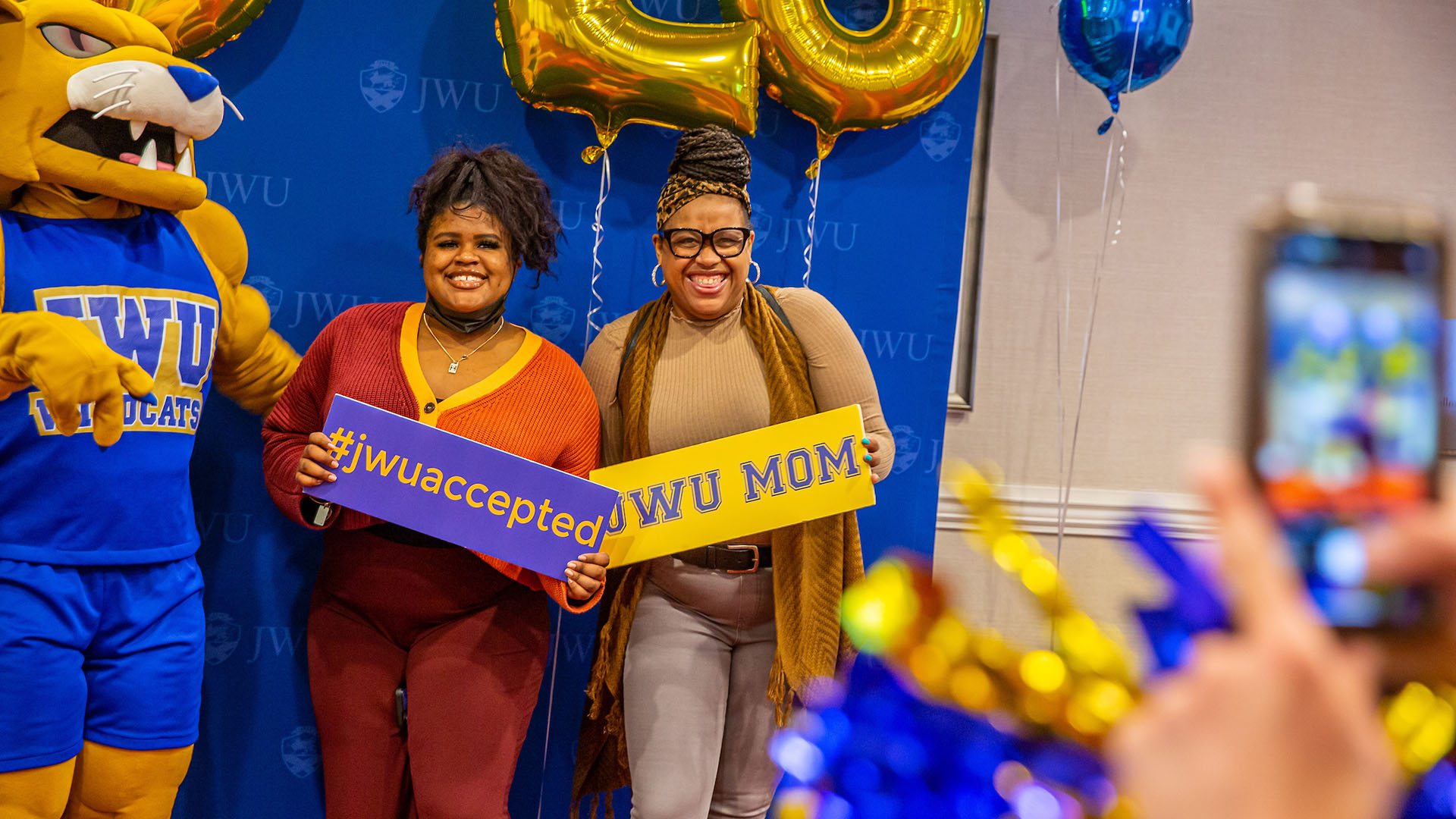 A mother and daughter pose with Wildcat Willie on Accepted Students Day