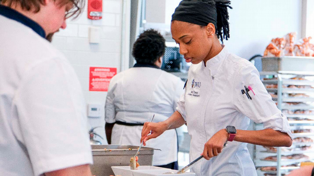 Culinary student Mali Towe cooking with other chefs