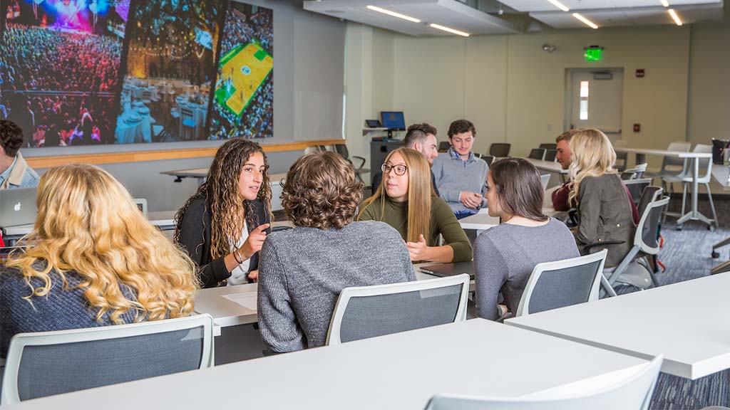 JWU Providence students working together in the SEEM Lab dressed in business casual attire.
