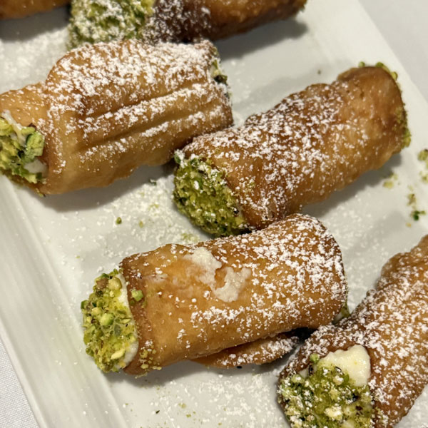 Pistachio cannolis filled with orange zested whipped ricotta.