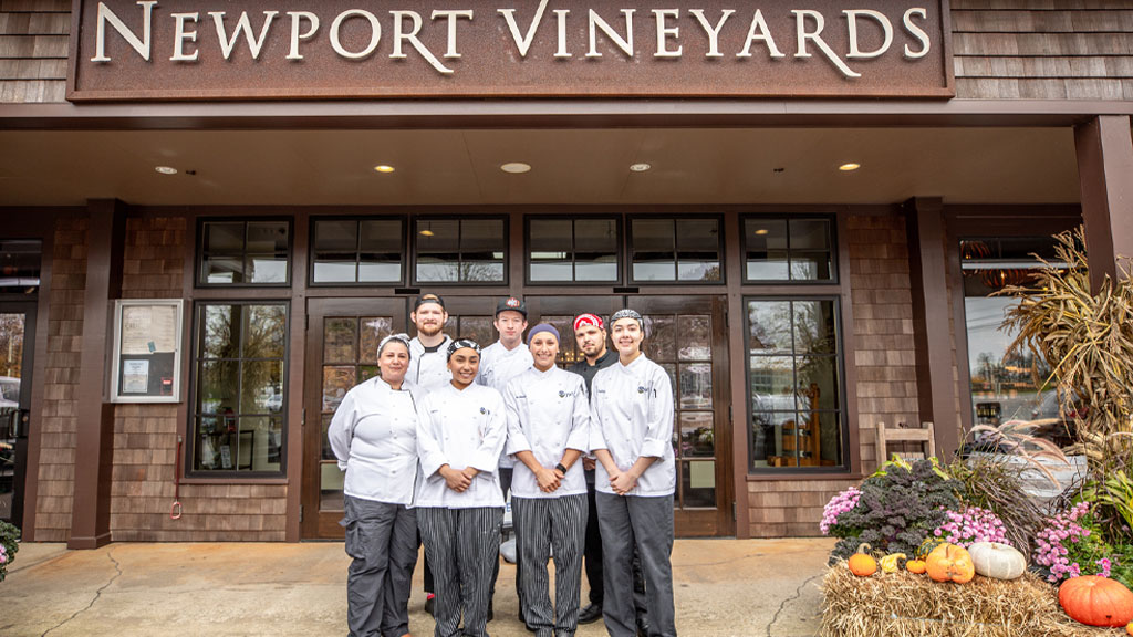 JWU student interns and alumni in front of the Newport Vineyards.