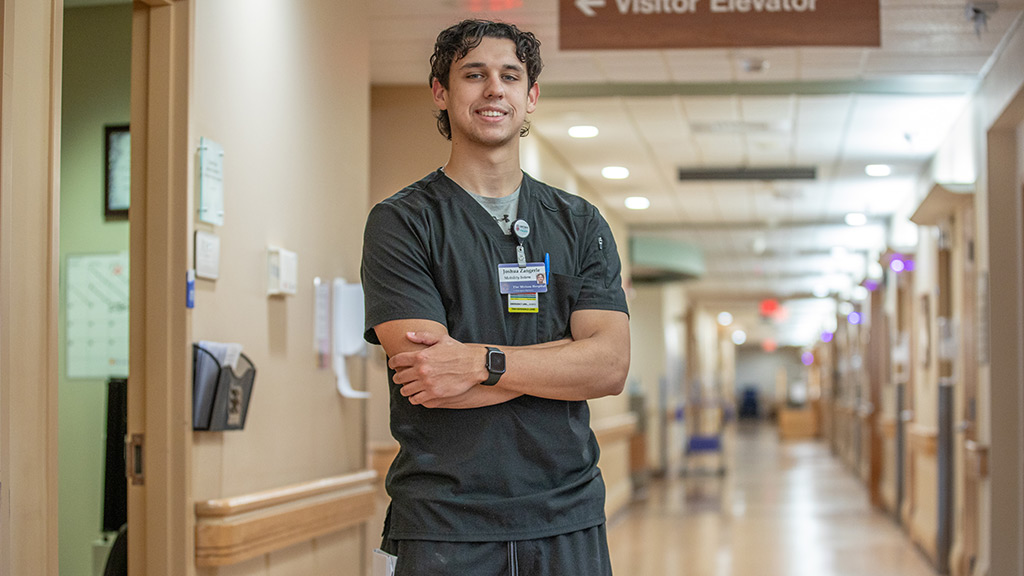 Josh Zangerle '25 smiles in a hallway at Brown University Health