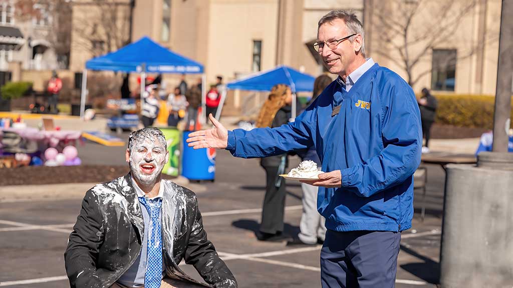 President Mathieu pieing SGA President John Billinis