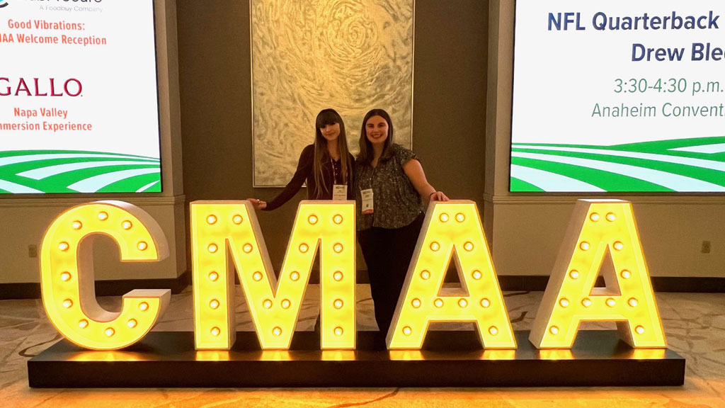 Students Cara Martino'26 and Ariana Adolph'27 at CMAA’s 2026 World Conference and Club Business Expo.