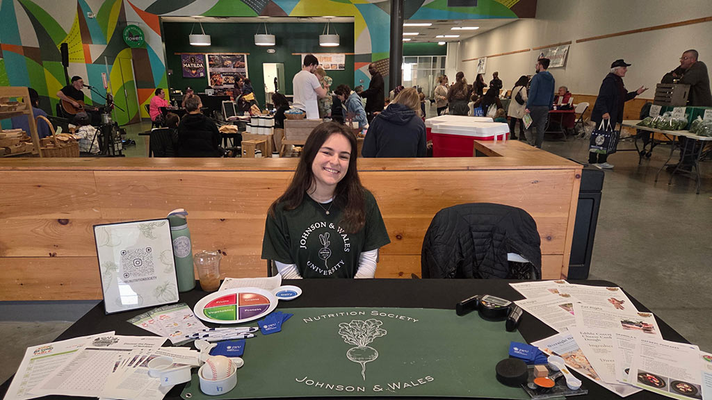 a JWU student tables for the Nutrition Society at Farm Fresh RI