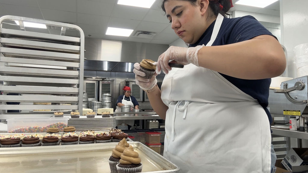 Briana Torres '26 completing frosting a mocha chocolate cupcake.