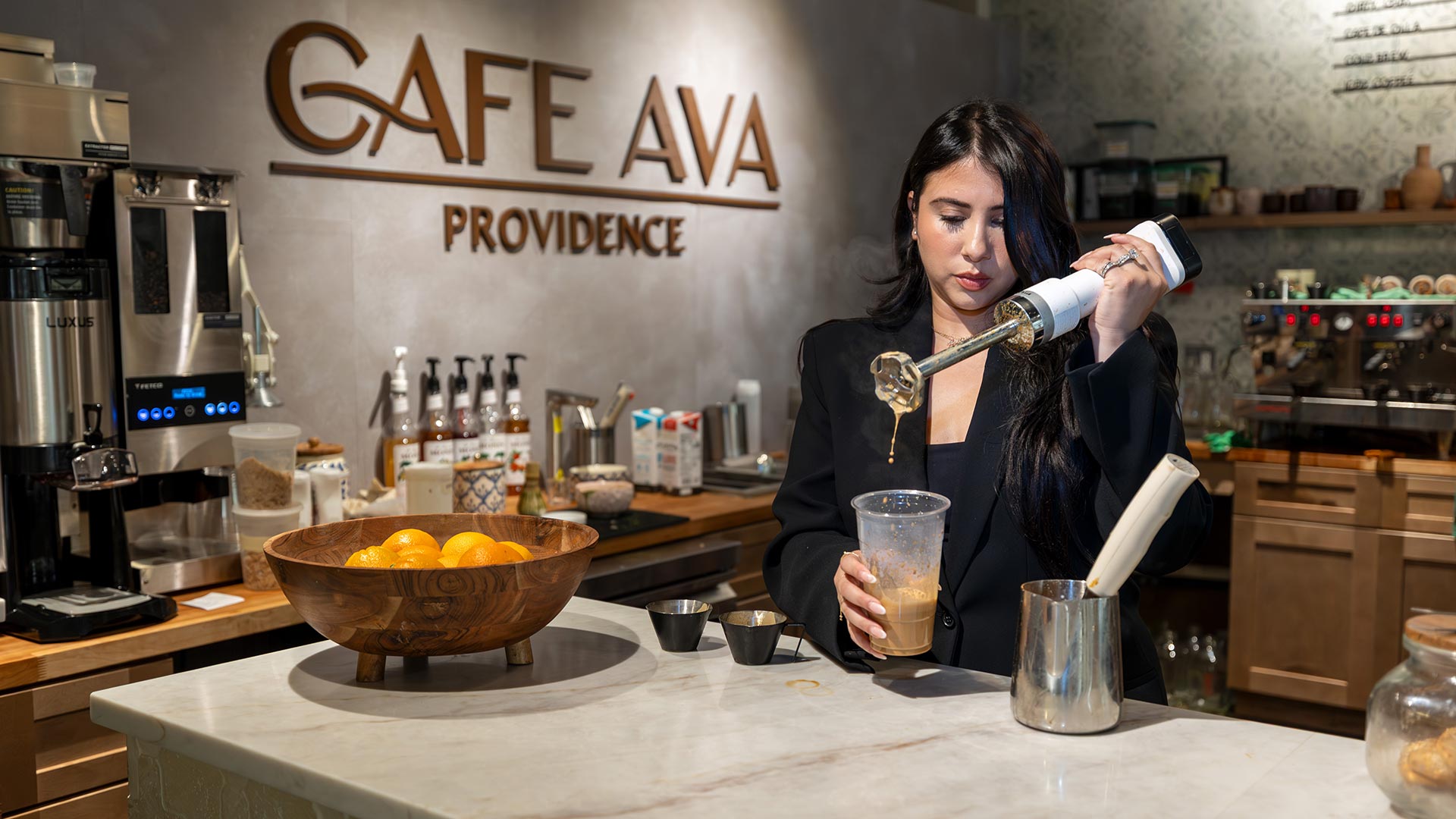 Andrea Cabrera pours a drink at the bar at Cafe Ava