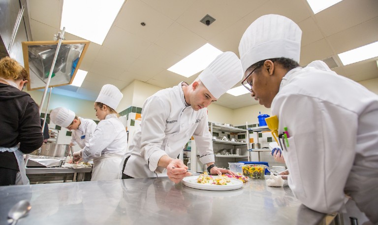 Chef Jon Poyourow in a culinary lab with JWU students