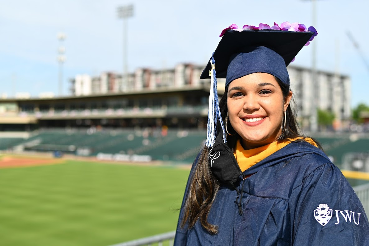 Smiling female JWU Charlotte student wearing a decorated mortar board.