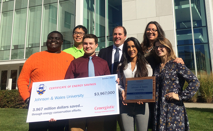 Students and faculty holding a large check and posing for a photo