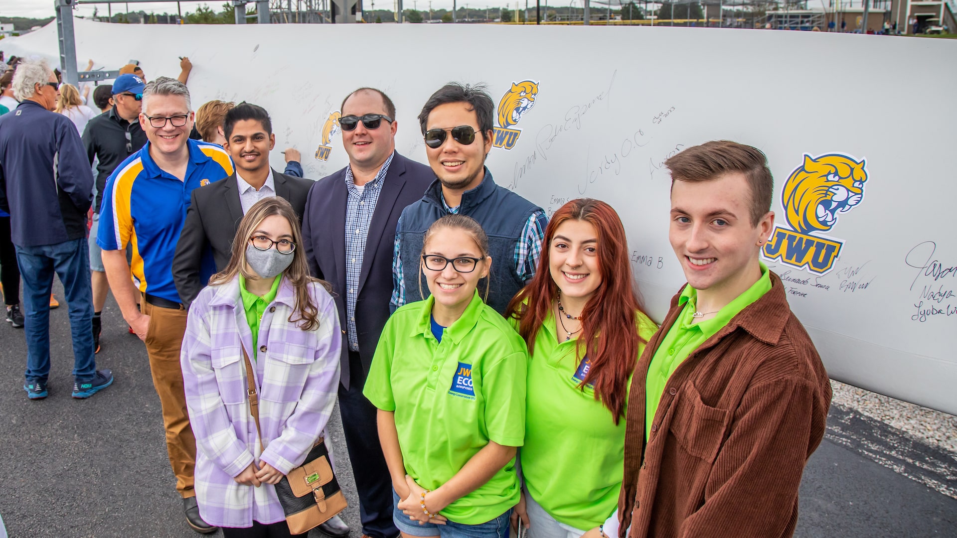 JWU staff and students in front of the newly-signed wind turbine blade that will be part of the Harborside Campus’ two new wind turbines.