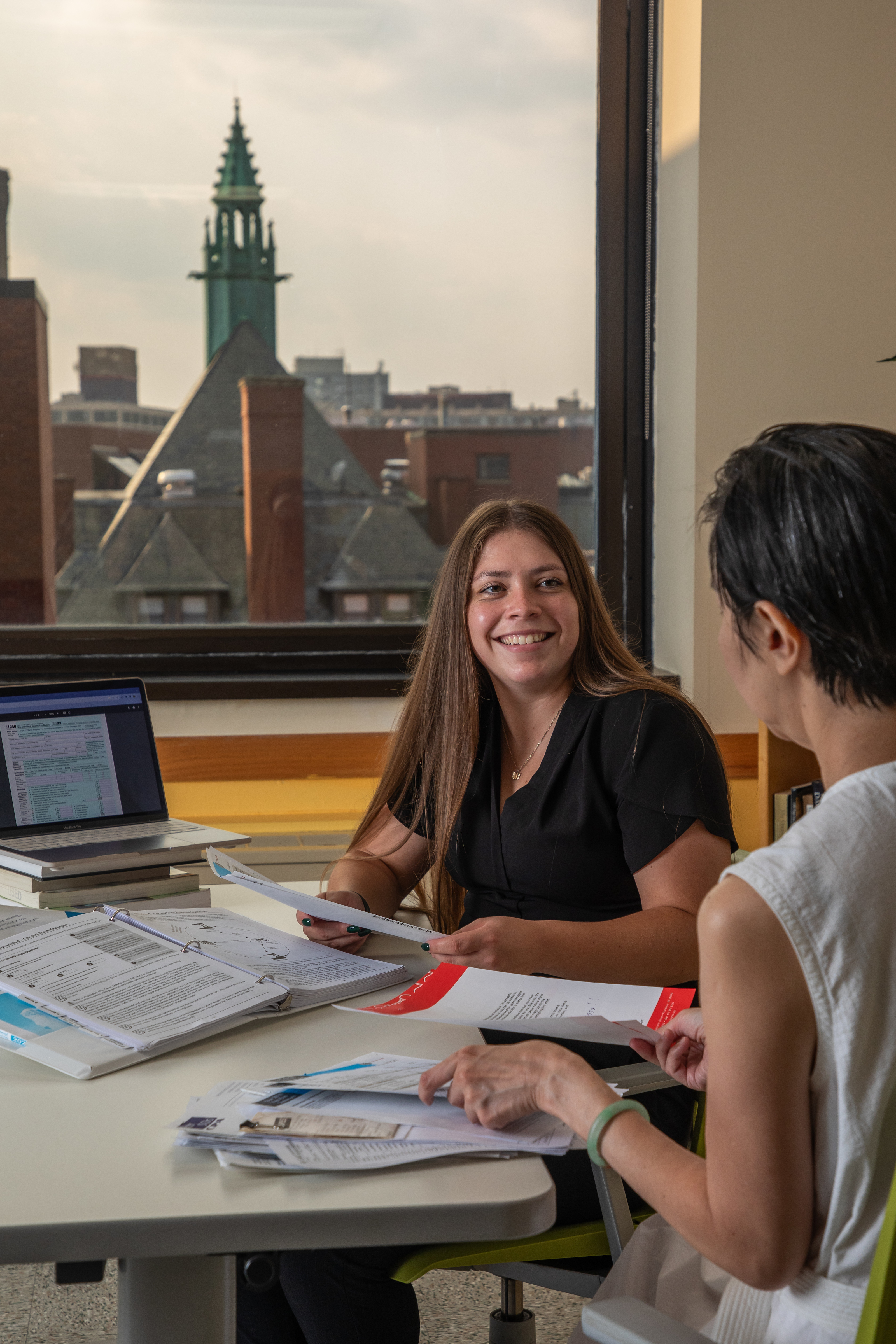 Accounting student sits discusses course work with professor